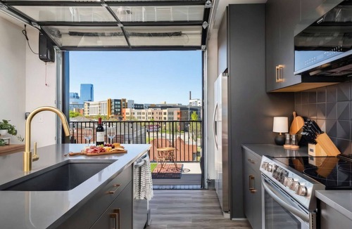 Rolling Mill Hill Apartment | Summer rooftop deck, skyline views, garage-door kitchen near Broadway