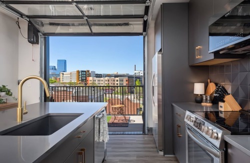 Rolling Mill Hill Apartment | Summer rooftop deck, skyline views, garage-door kitchen near Broadway